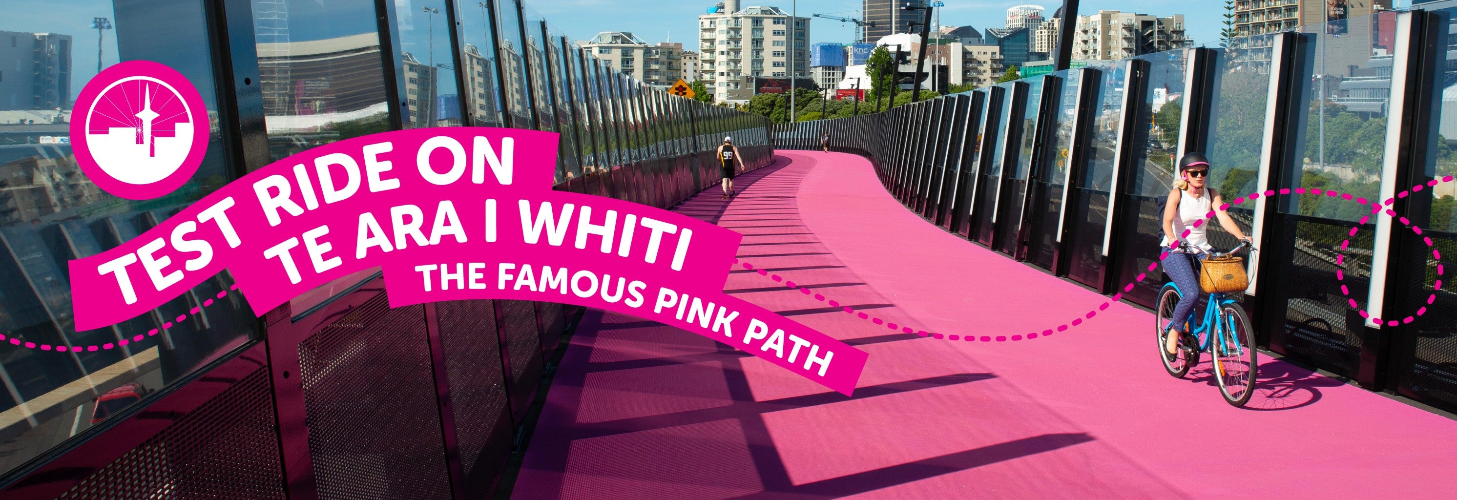 Bright pink cycling path on sunny day with text promoting 'Te Ara I Whiti' in a city setting